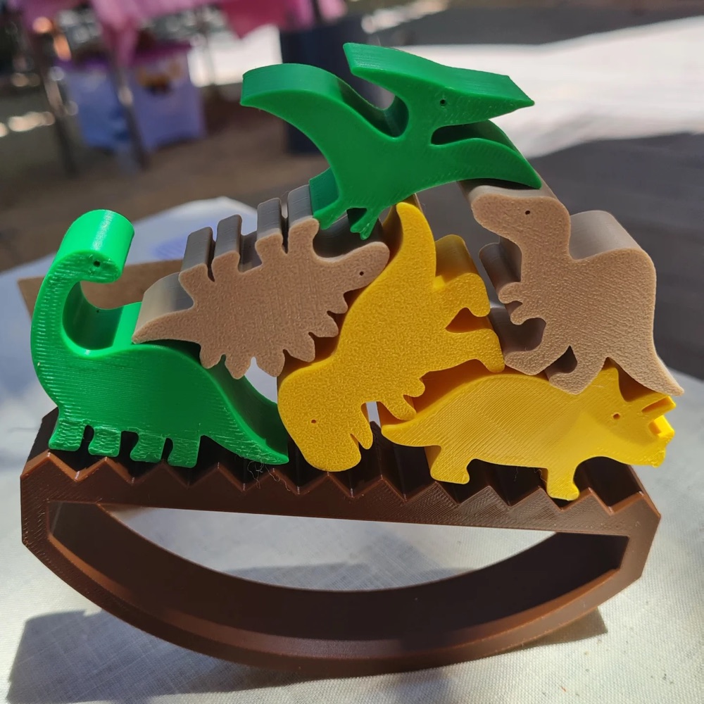 Dinosaurus cetak 3D di atas balok kayu