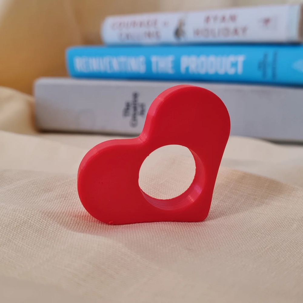 Hati merah cetak 3D di atas tumpukan buku