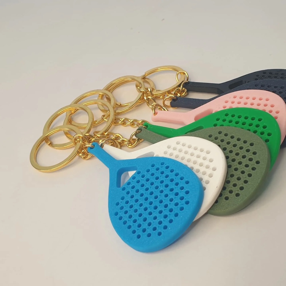 Gantungan kunci raket padel cetak 3D warna biru, putih, pink dan hijau